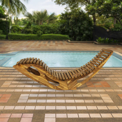 Die ergonomische Schwungliege Saunaliege aus Akazienholz - FSC® zertifiziert von HC Garten & Freizeit steht auf einer gefliesten Poolterrasse, umgeben von üppigem Grün und lädt zum Entspannen ein.