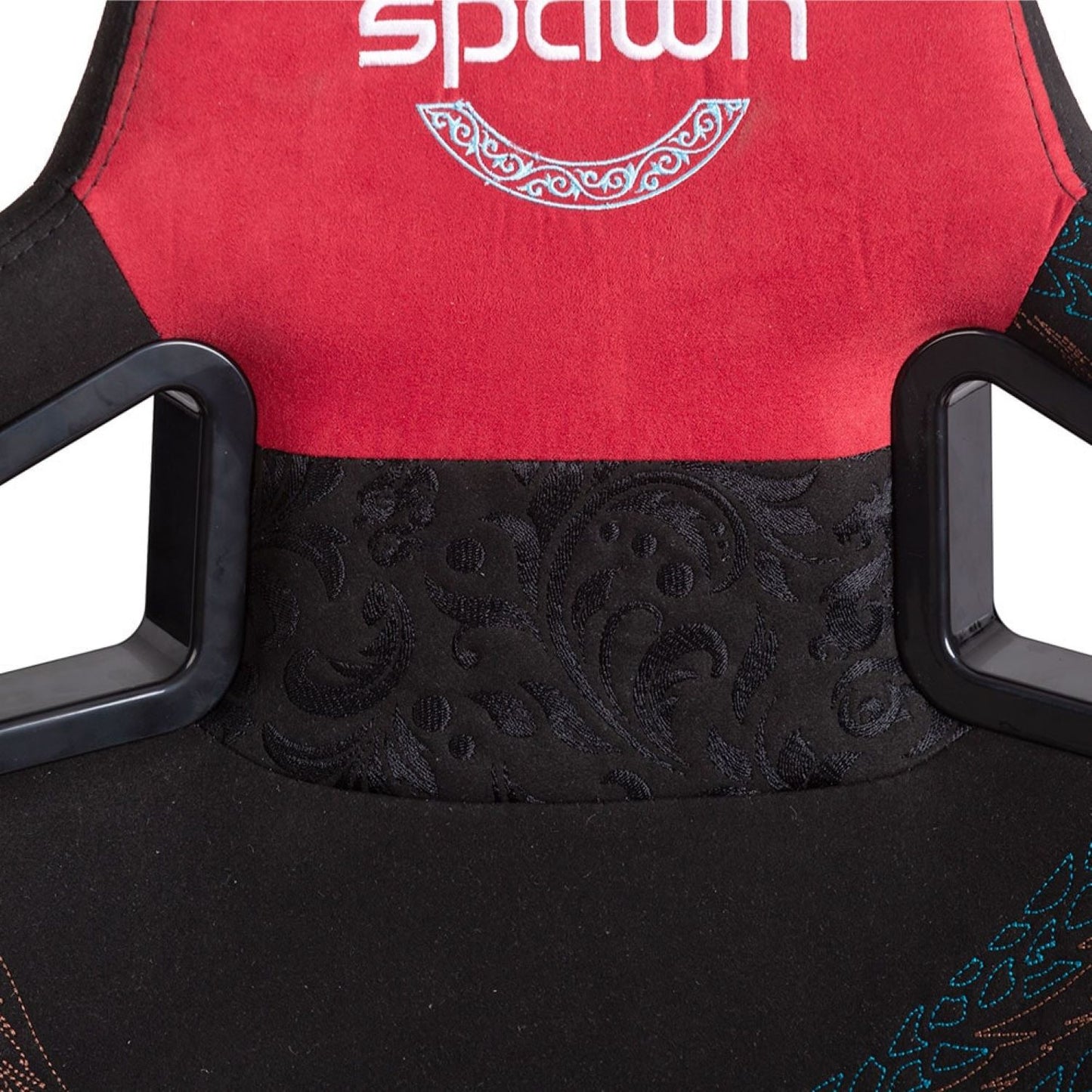 Nahaufnahme der oberen Rückenlehne des Spawn Gaming Stuhls "Dragon" von Spawn, mit roter und schwarzer Polsterung mit dekorativen Mustern und dem Wort "Spawn", das oben teilweise sichtbar ist.