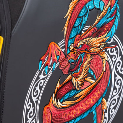 Nahaufnahme eines gestickten roten, orangen und blauen Drachens mit scharfen Krallen auf dunklem Stoff, dargestellt auf dem Spawn Gaming Stuhl "Dragon" von Spawn, mit 4D-Armlehnen und einem dekorativen weißen Kreismuster.